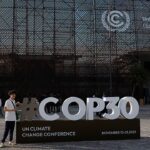 شخص ينظر إلى لافتة مؤتمر المناخ كوب 30